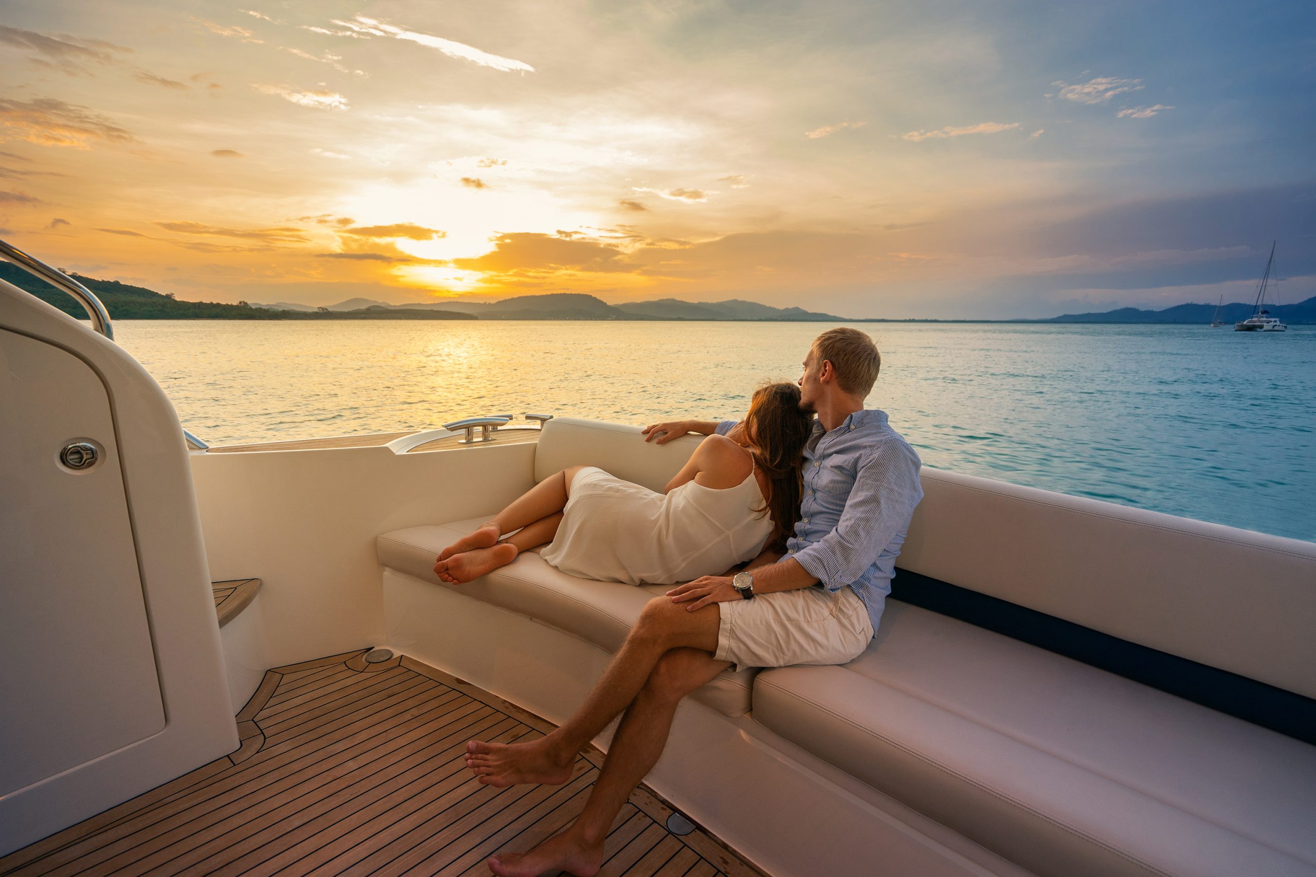 Romantic vacation . Beautiful couple looking in sunset from the yacht.