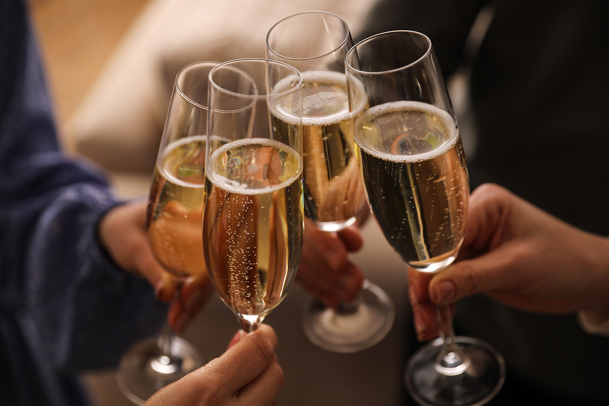 People clinking glasses with champagne at home, closeup